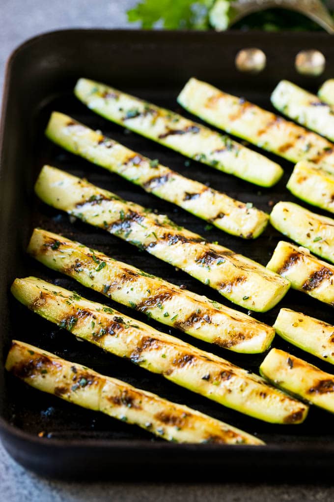 A grill pan full of sticks of zucchini being cooked to perfection.