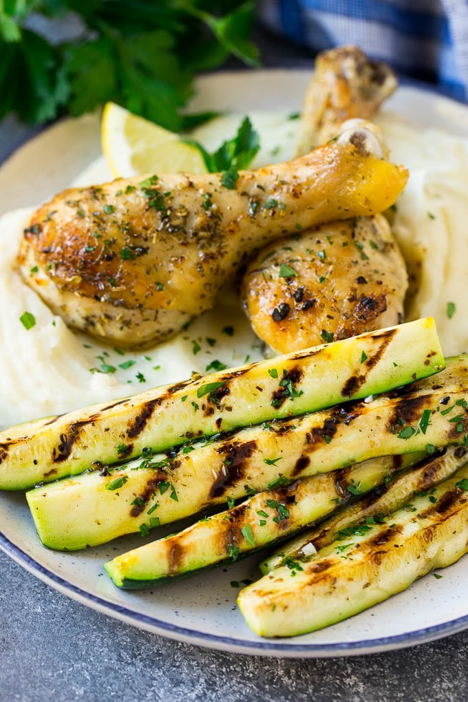 Grilled zucchini served alongside chicken and mashed potatoes.
