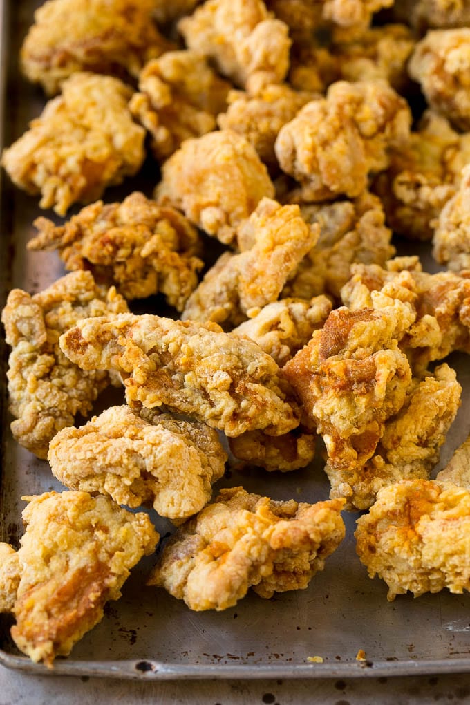 Fried chicken thigh pieces on a sheet pan.