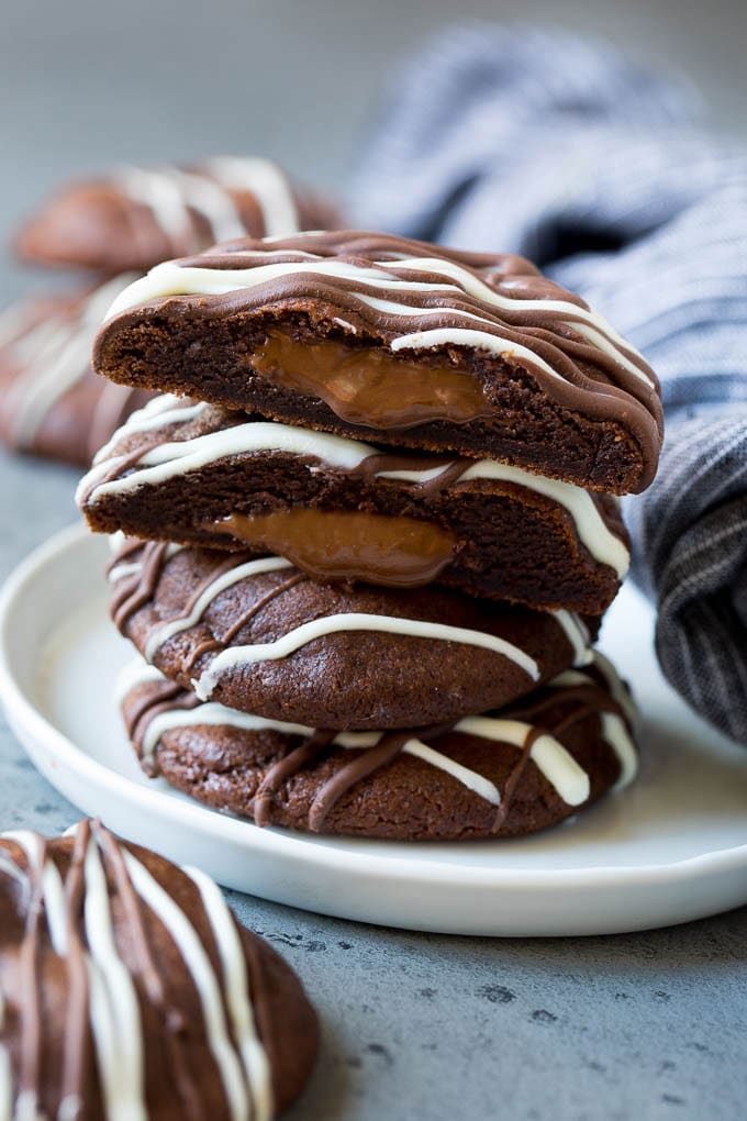 A stack of Nutella cookies on a plate with one cut open.