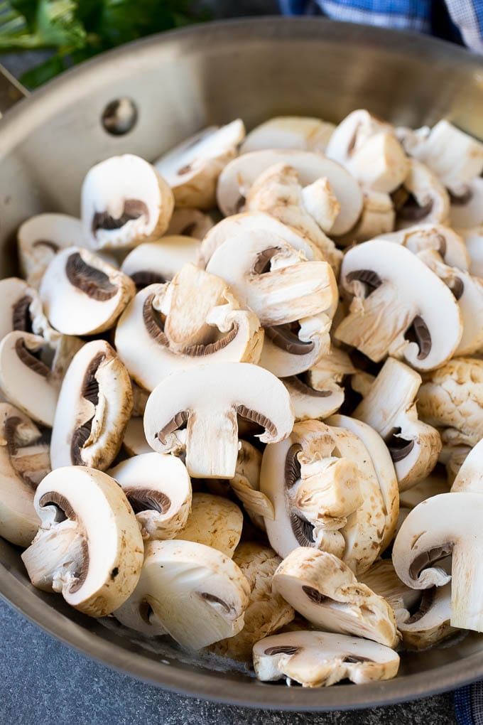 Sliced button mushroom in a frying pan.