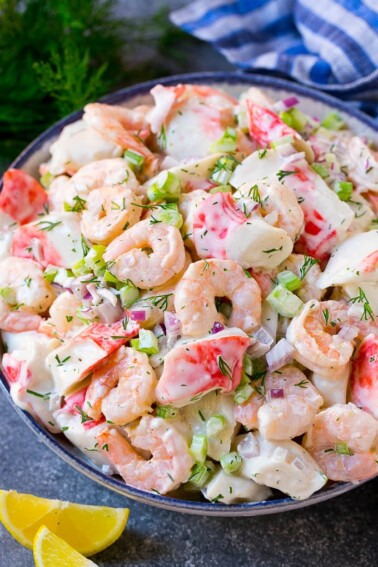 A serving bowl of seafood salad made with shrimp and imitation crab in a creamy dill dressing.