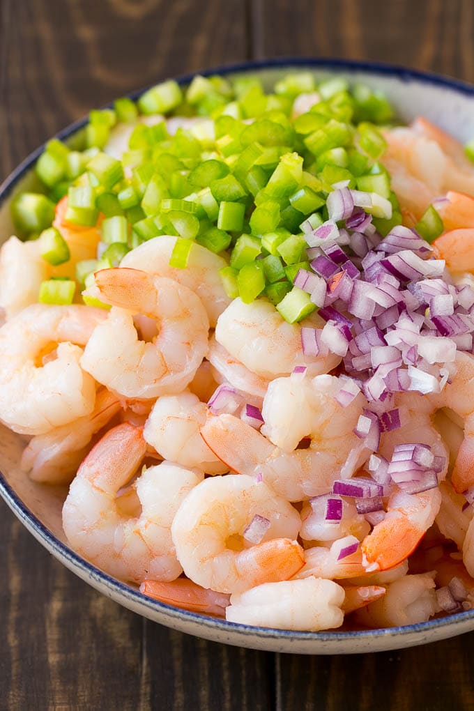 Shrimp, celery and red onion in a bowl.
