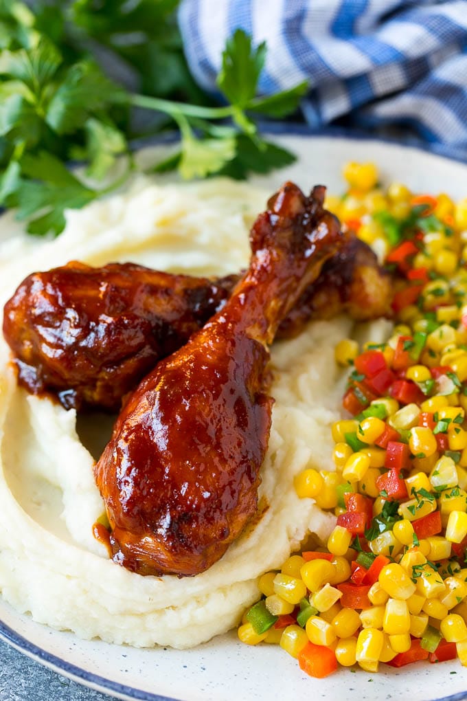 Slow cooker chicken drumsticks served with mashed potatoes and corn.