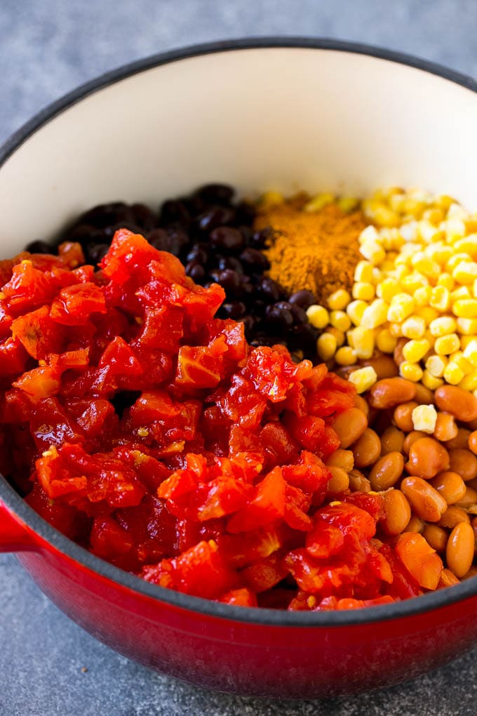 Ground beef, taco seasoning, canned tomatoes, beans and corn in a soup pot.