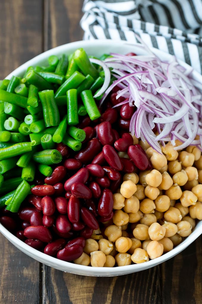 Green beans, kidney beans, garbanzo beans and red onion in a bowl.