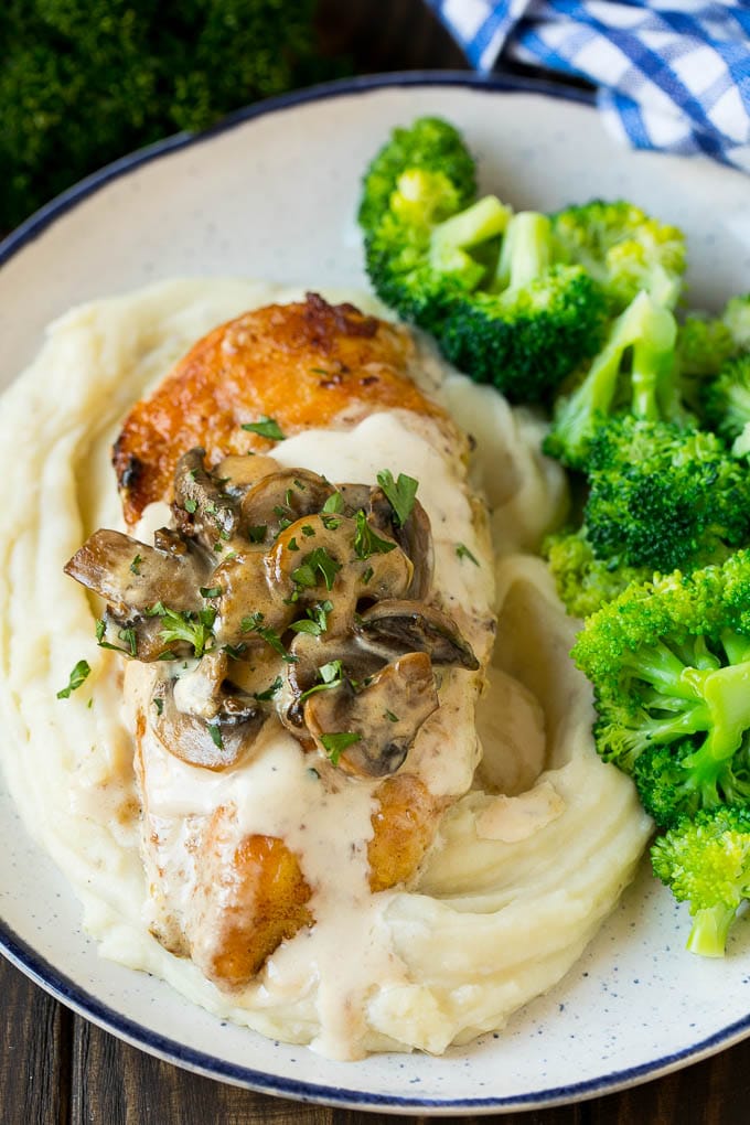 Instant Pot chicken with creamy mushroom sauce served over mashed potatoes with a side of broccoli.