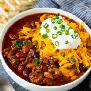 A bowl of Instant Pot chili topped with sour cream, cheese and green onions.