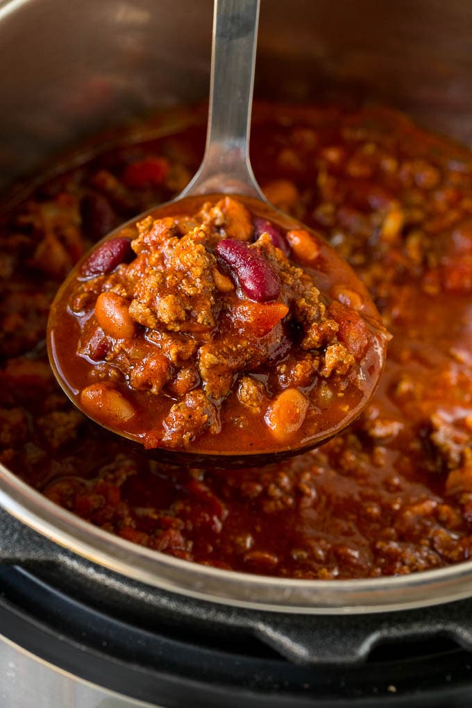 A ladle full of Instant Pot chili with beef and beans.
