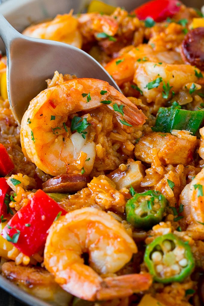 A spoon serving up jambalaya with shrimp, okra and rice.