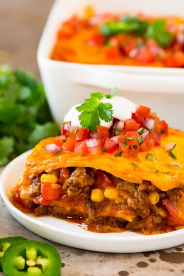 A plate of Mexican casserole with layers of meat, tortillas and cheese.