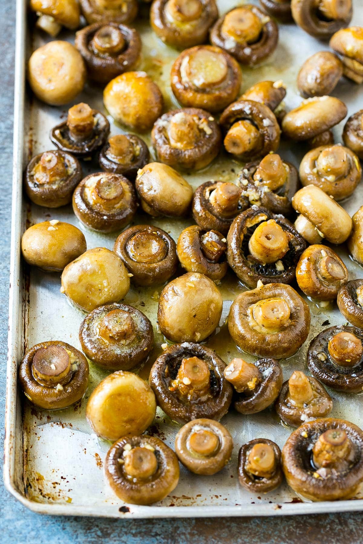 Cooked mushrooms on a sheet pan with garlic butter.
