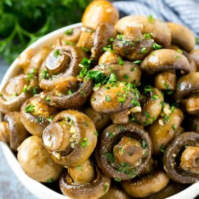 A bowl of roasted mushrooms topped with fresh parsley.