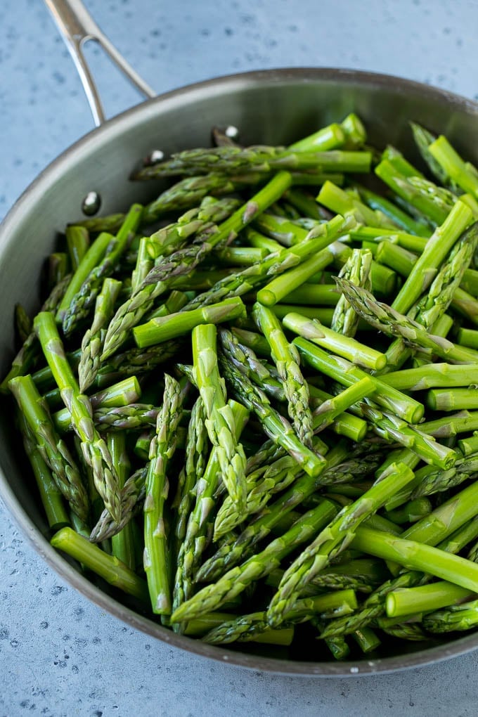 Raw chopped asparagus stalks in a frying pan.