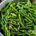 Sauteed asparagus with butter, garlic and herbs in a skillet.