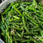 Sauteed asparagus with butter, garlic and herbs in a skillet.