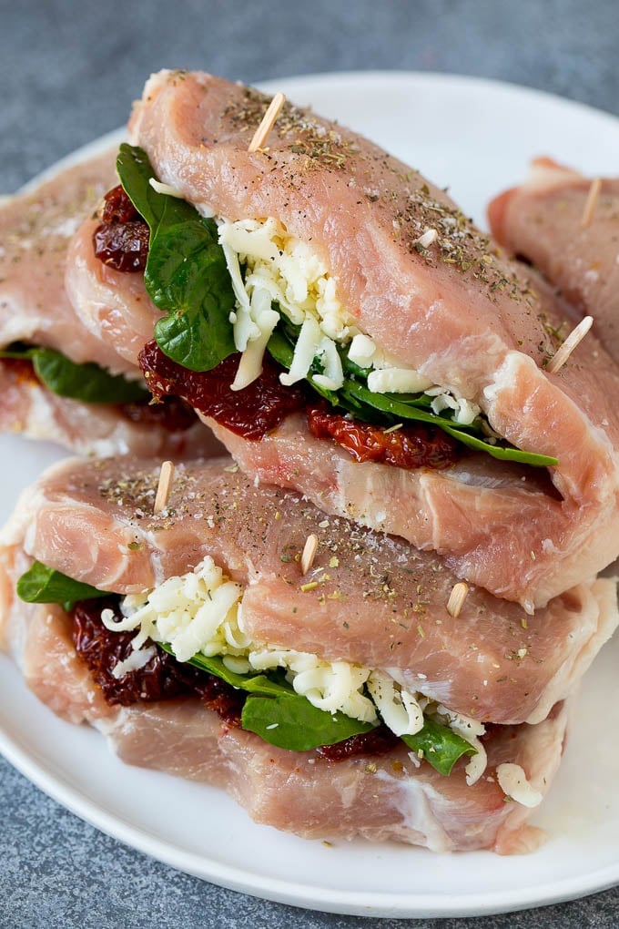 Boneless pork chops split in half and stuffed with spinach leaves, sun dried tomatoes and shredded cheese.