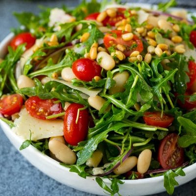 Arugula salad made with white beans, tomatoes, parmesan cheese and pine nuts.