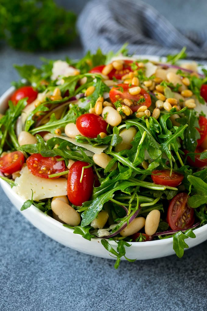 Arugula salad made with white beans, tomatoes, parmesan cheese and pine nuts.