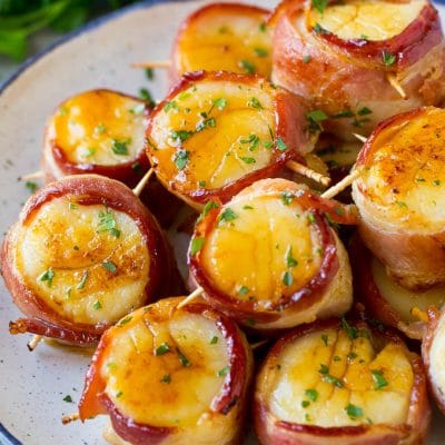 Bacon wrapped scallops coated in glaze and topped with parsley.