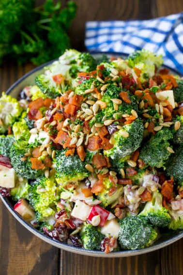 Broccoli salad in a creamy dressing topped with sunflower seeds and bacon.