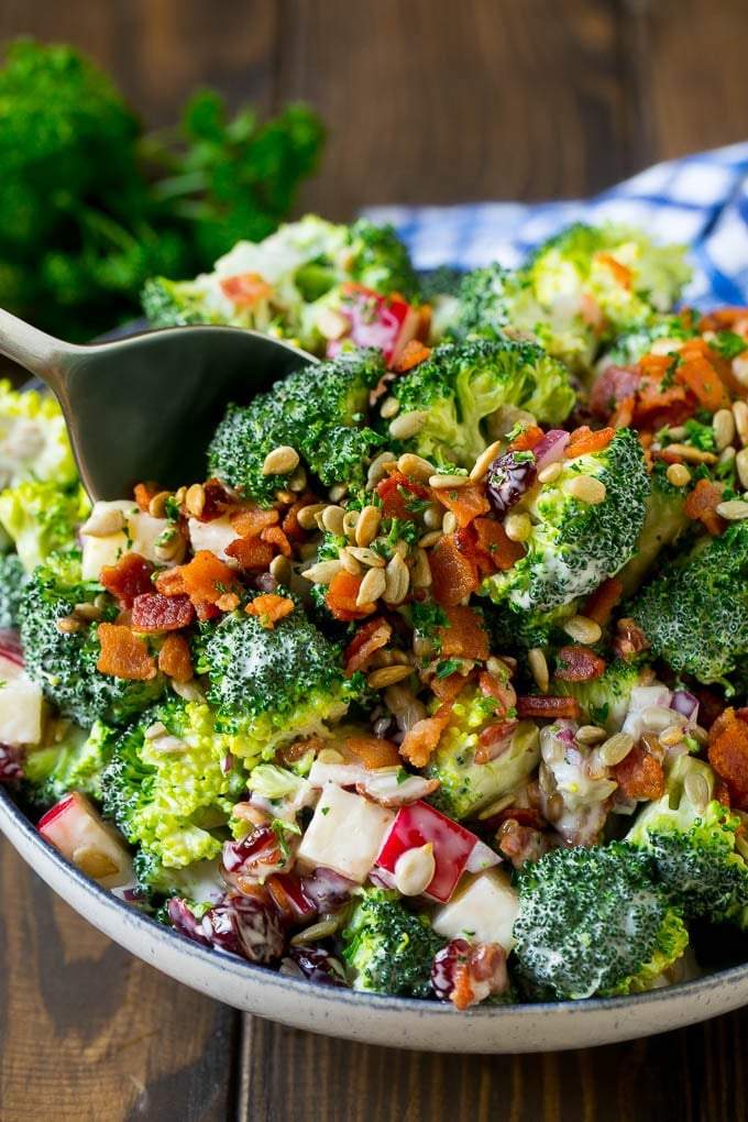 A serving spoon in a bowl of bacon broccoli salad.