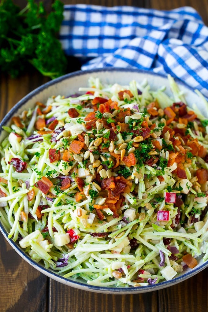 A bowl of broccoli slaw tossed in a creamy dressing with bacon and sunflower seeds.