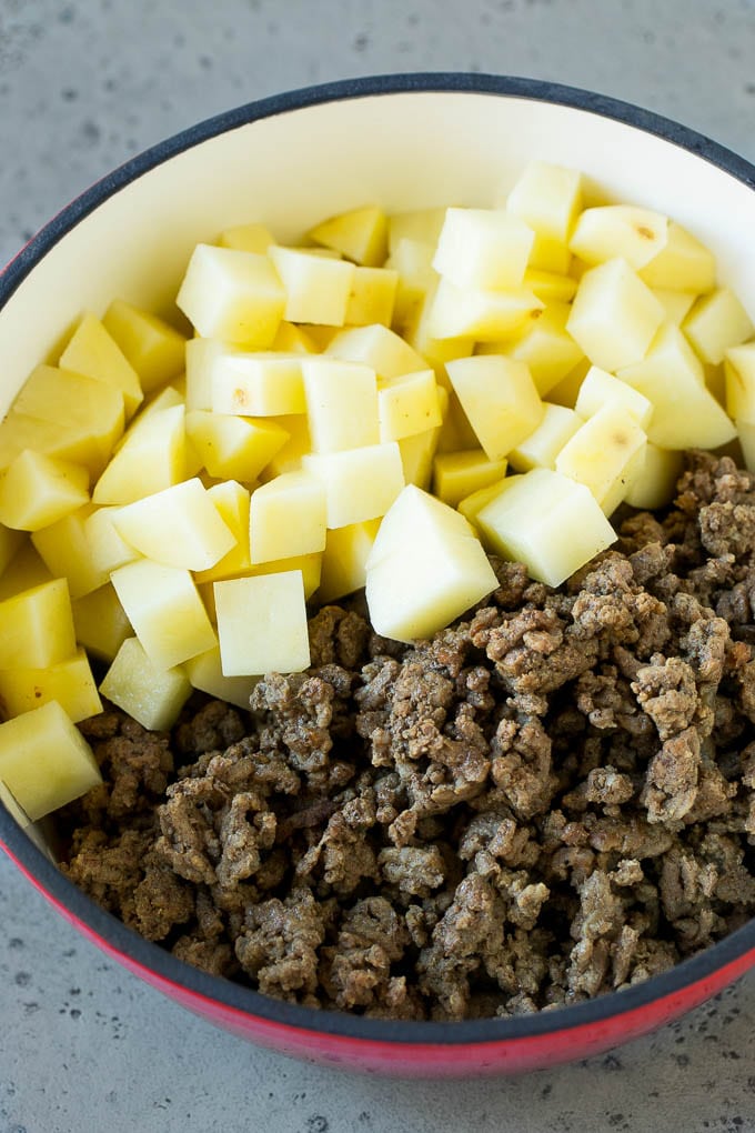 Cheeseburger Soup Recipe | Hamburger Soup | Cheese Soup #soup #groundbeef #hamburger #cheese #bacon #dinner #dinneratthezoo Cooked ground beef and potatoes in a pot.
