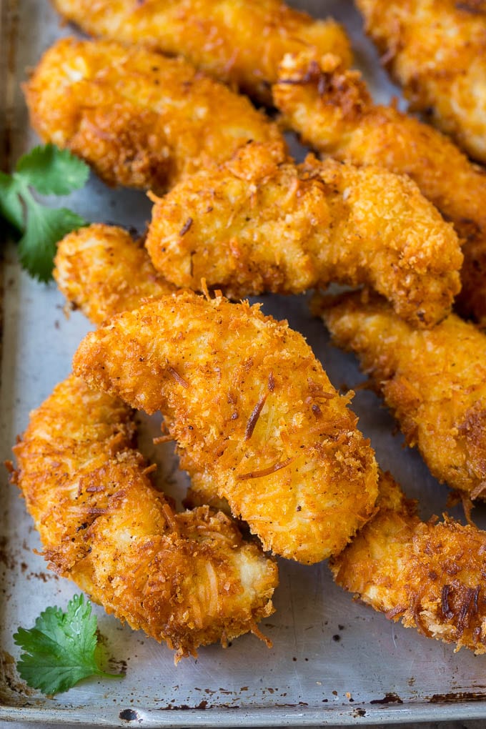 Fried coconut chicken fingers with cilantro for garnish.