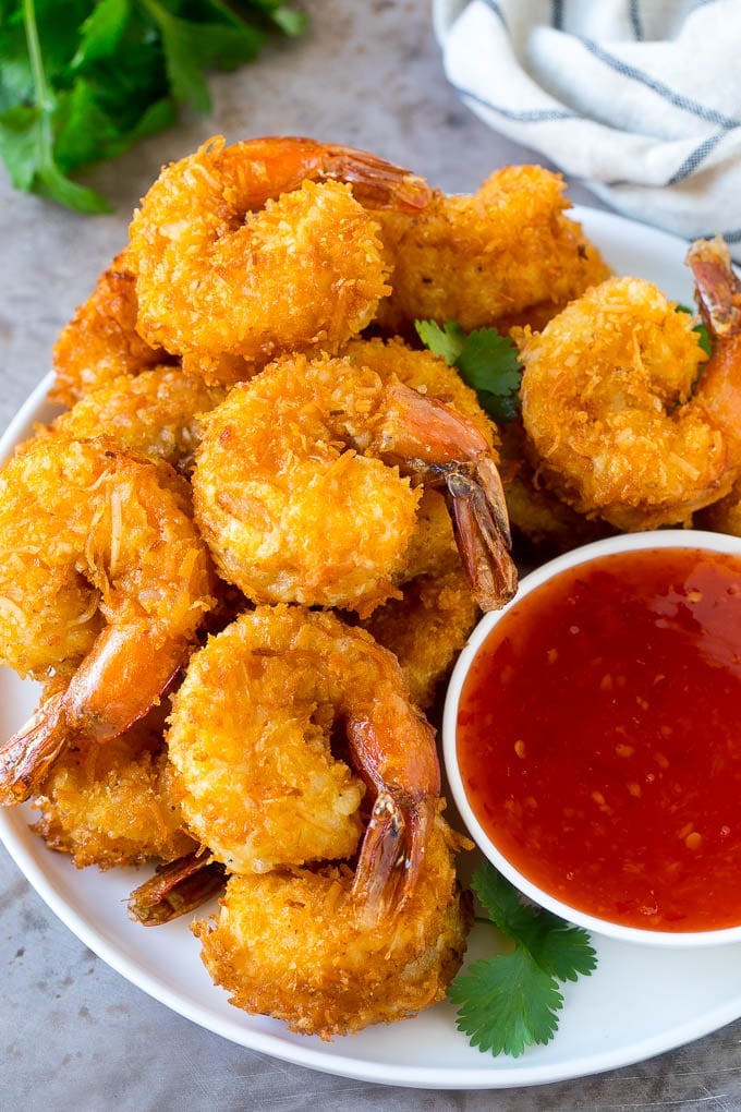 A plate of coconut shrimp with a bowl of sweet chili sauce.