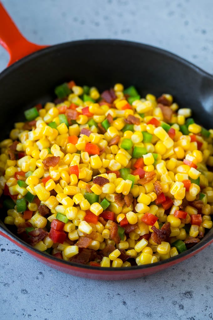 Corn, bacon and bell peppers in a skillet.