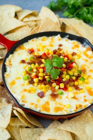 Hot corn dip made with two types of cheese, corn, peppers and bacon, served with tortilla chips.