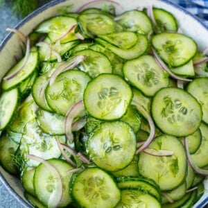 Cucumber salad in a serving bowl with sliced English cucumbers, red onion and fresh dill.