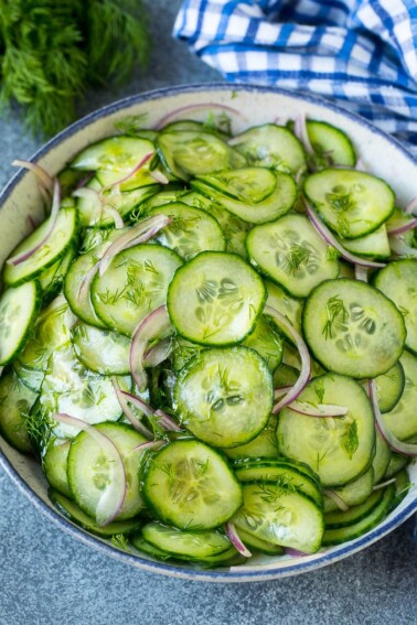 Cucumber salad in a serving bowl with sliced English cucumbers, red onion and fresh dill.