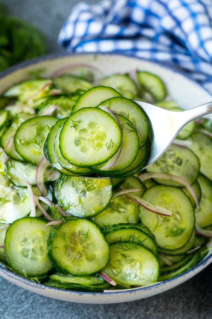 A spoon serving up a portion of classic cucumber salad.