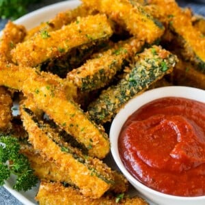 A p late of fried zucchini served with marinara for dipping.