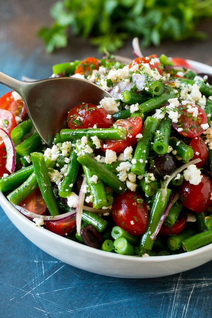 A serving spoon in a bowl of green bean salad.