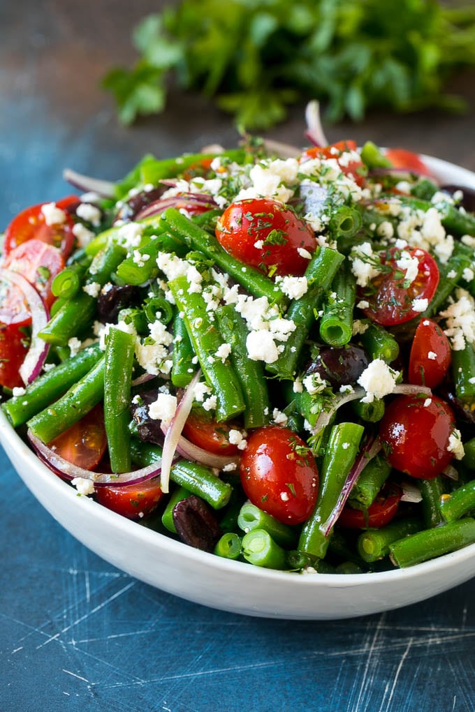 Green bean salad tossed in a vinaigrette and topped with feta cheese and herbs.