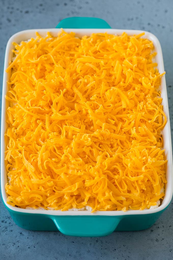 A hash brown casserole covered with shredded cheddar cheese!