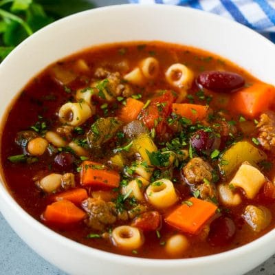 A bowl of pasta e fagioli soup with colorful veggies, ditalini pasta, two types of beans and ground beef.