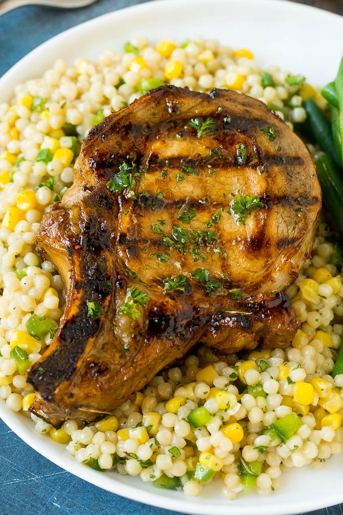 A grilled marinated pork chop served over couscous.