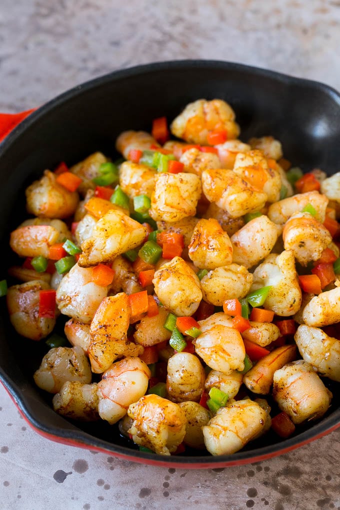 A skillet full of chopped shrimp and bell peppers.