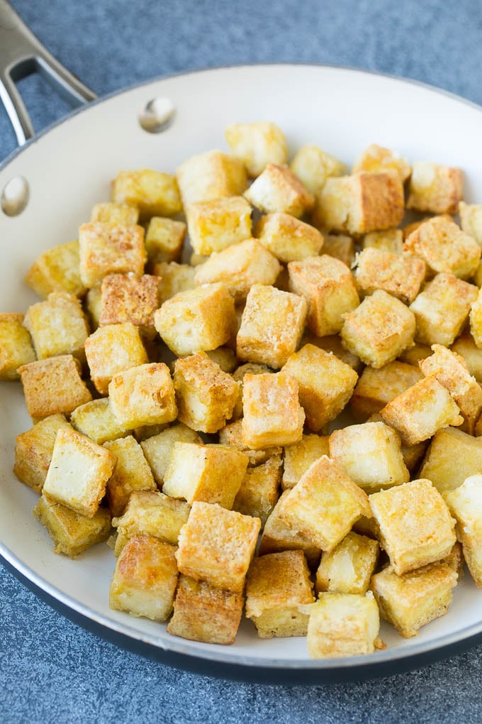 Cubes of crispy sauteed tofu in a skillet.