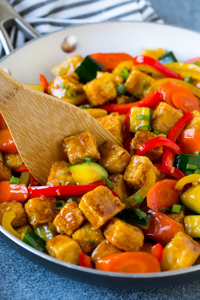 A p an of tofu stir fry with a spatula in it.