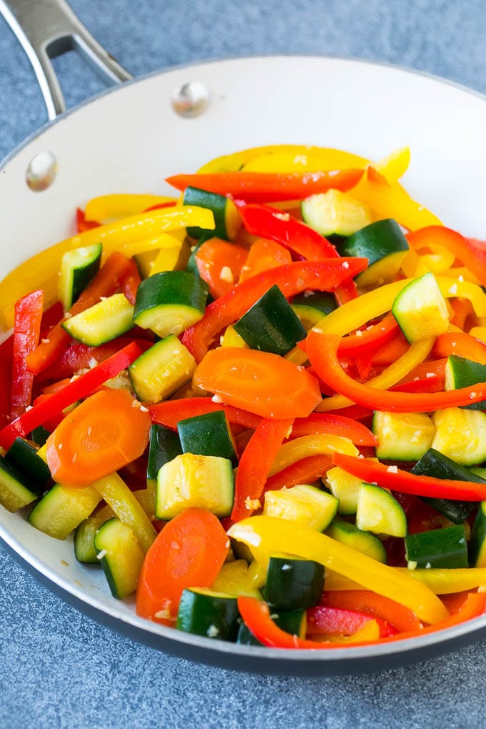 A pan of sauteed peppers, zucchini and carrots.