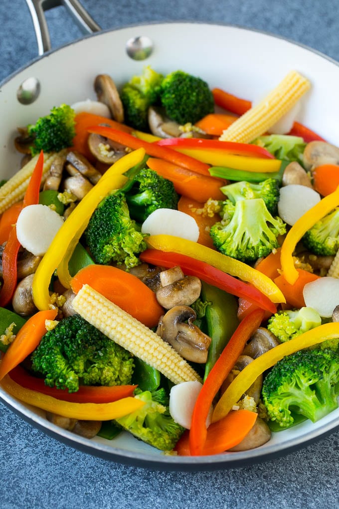 A pan of sauteed baby corn, water chestnuts, peppers, broccoli and mushrooms.