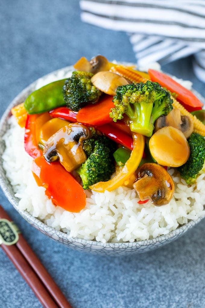 Vegetable stir fry served over rice in a bowl.