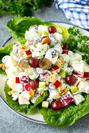 Waldorf salad with apples, grapes, celery and pecans, served on a bed of lettuce leaves.