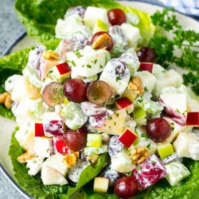 Waldorf salad with apples, grapes, celery and pecans, served on a bed of lettuce leaves.