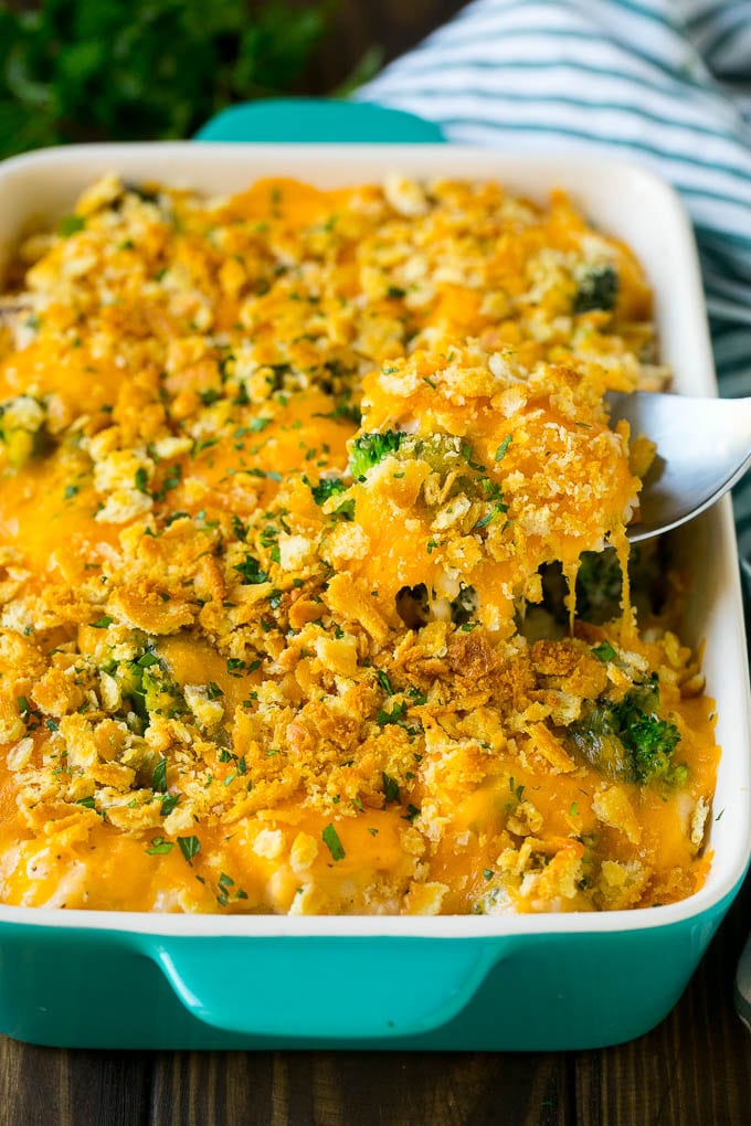 A spoon serving up a portion of chicken casserole made with rice and broccoli.